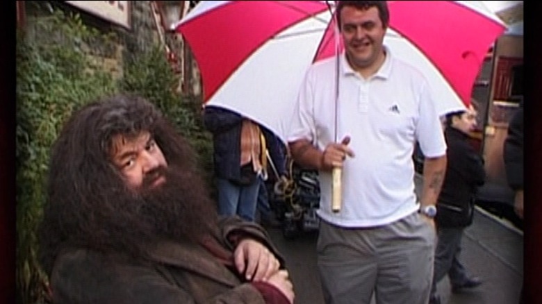 Robbie Coltrane in his Hagrid costume under an umbrella