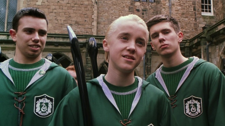 Malfoy sneering surrounded by Slytherins