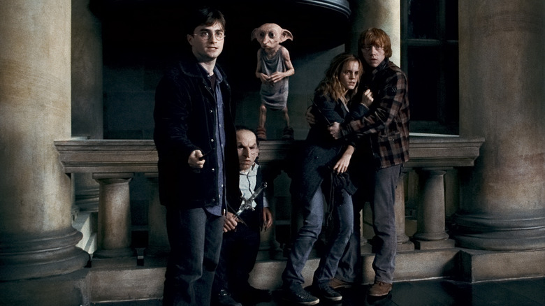 Harry and his friends with wands, looking scared