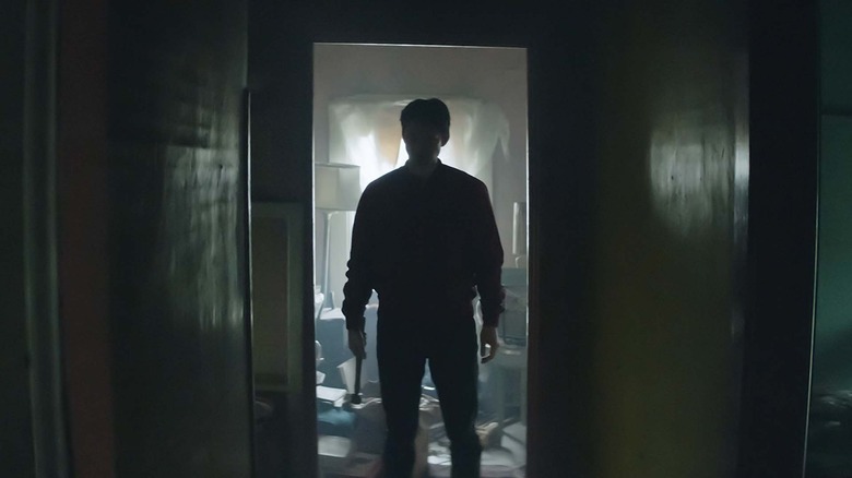 James menacingly standing in a doorway