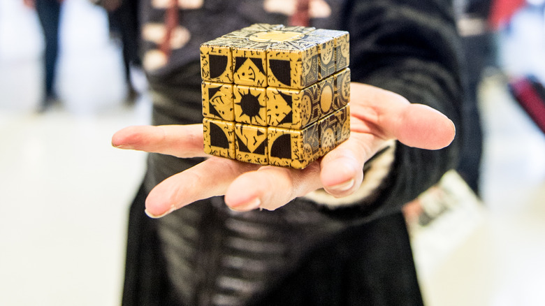 A cosplayer holding a fan-made replica of the Lament Configuration 