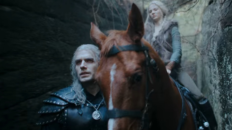 Geralt leads Roach and Ciri through a mountain pass