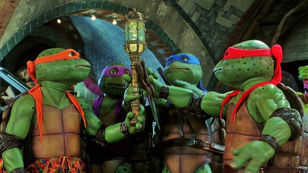 The Teenage Mutant Ninja Turtles holding a scepter