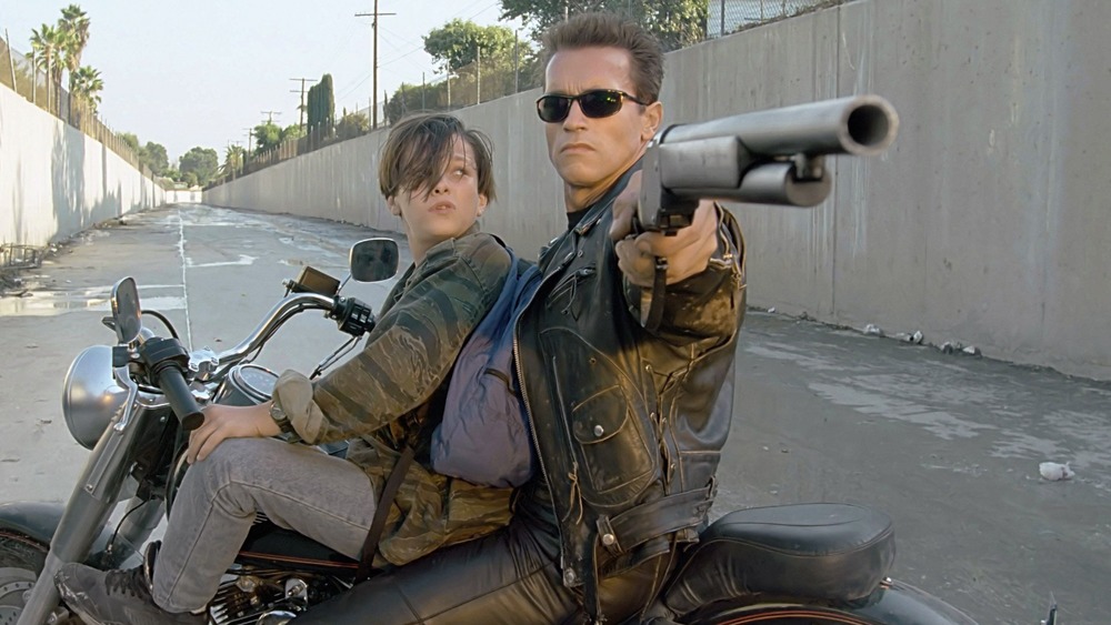 T-800 protecting young John Connor with a shotgun