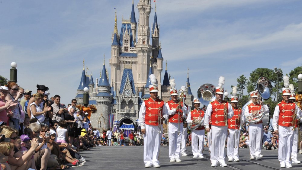 A marching band performs in front of Cinderella's castle at Walt Disney World