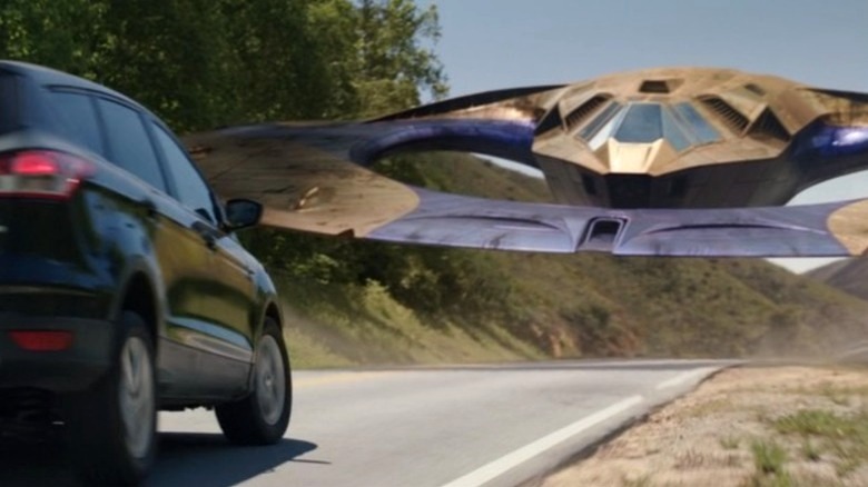 A Sakaaran space ship in front of a car