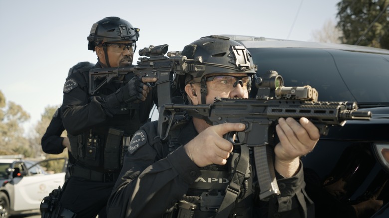 Hondo and Dominique holding rifles