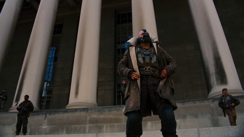 Bane standing outside a building