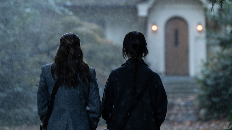 Missionaries standing outside house