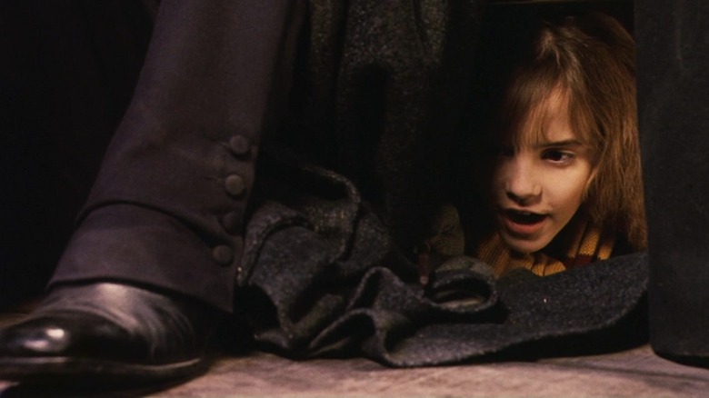 Hermione's face behind Snape's leg