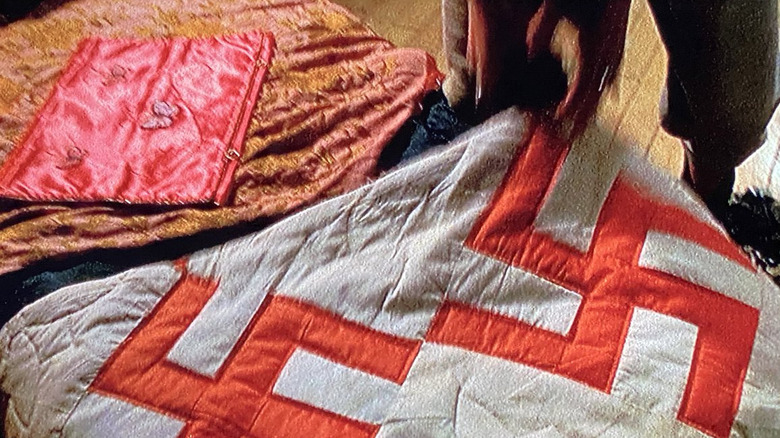 A white quilt with red swastikas on it