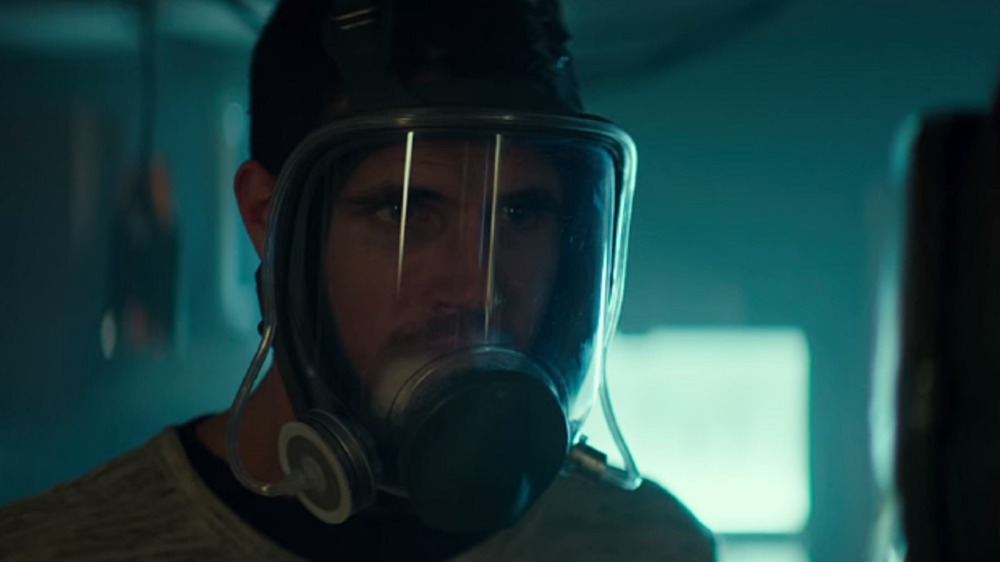 Robbie Amell wearing a gas mask in ARQ