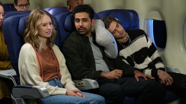 Sid sitting between two strangers on a plane