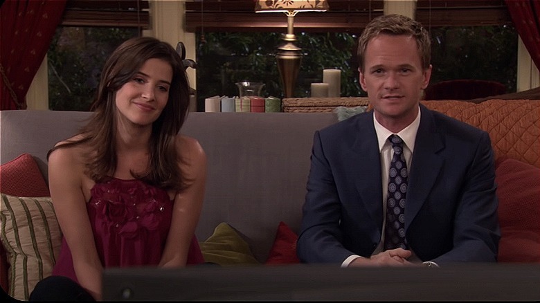 Robin and Barney smiling and sitting on the couch