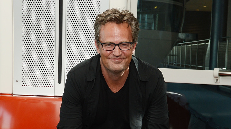 Matthew Perry grinning black glasses