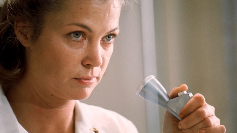 Nurse Ratched holding microphone