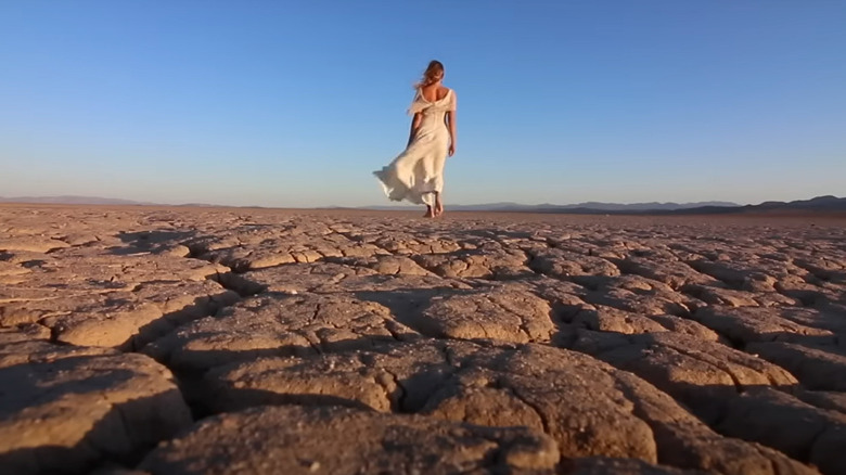 blonde woman walking across desert