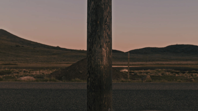 Telephone pole with a symbol carved into it