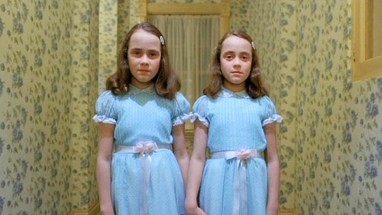 The twin girls standing in the hallway