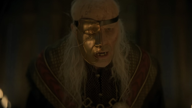 Paddy Considine as old King Viserys wearing a gold mask