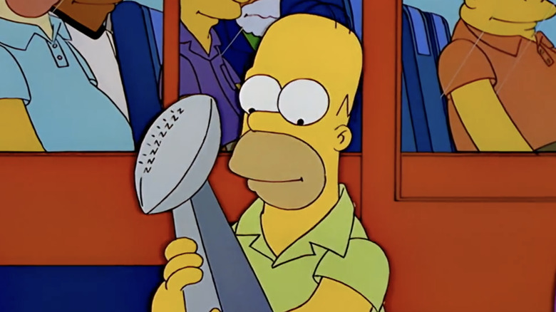 Homer Simpson holding the Super Bowl trophy