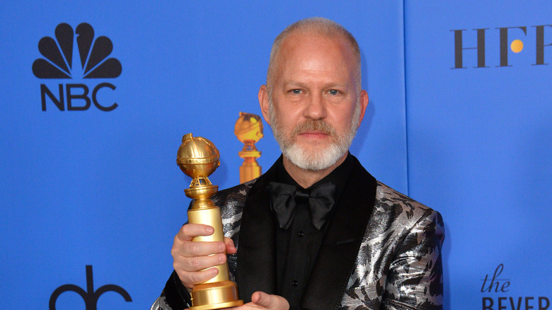 Ryan Murphy holding a golden globe