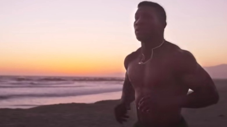 Damian Anderson running shirtless on beach