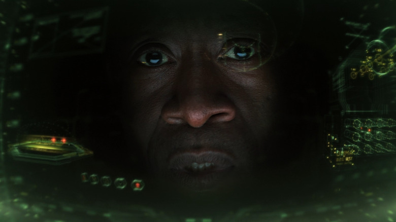 Rhodey's face inside his armor looking at technological information