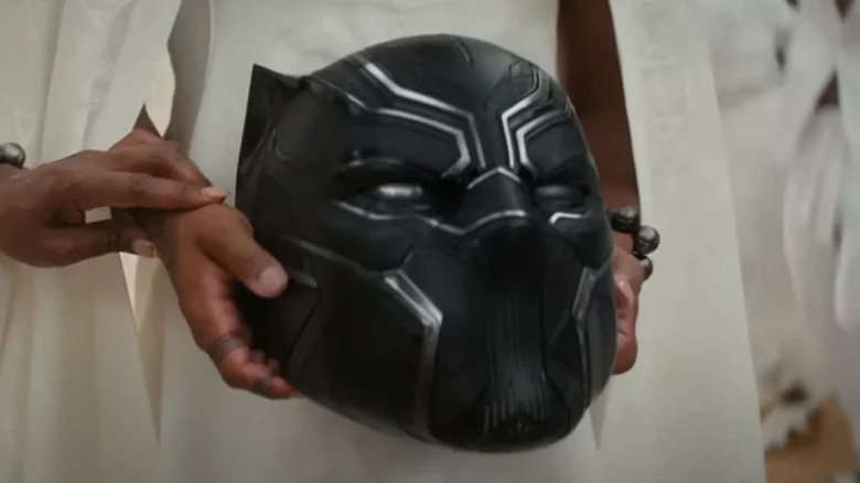 Hands holding Black Panther helmet