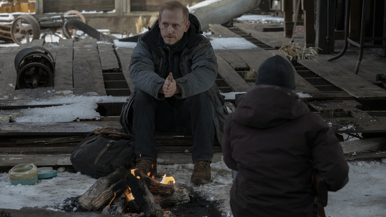 David and Ellie sit by the fire