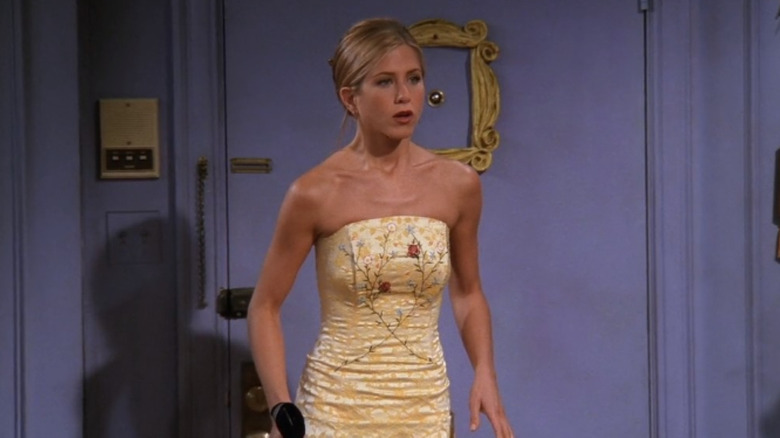 Rachel stands in a gold strapless dress