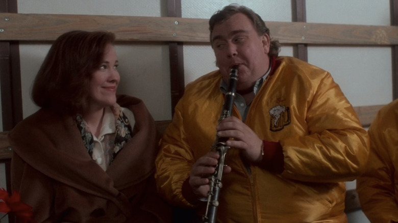 Kate McCallister smiling and Gus playing the clarinet