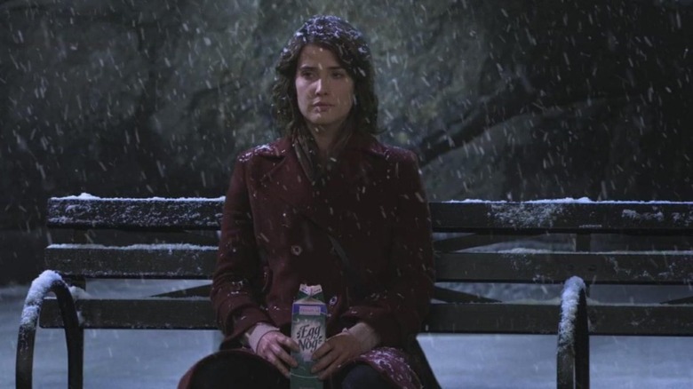 Robin sitting alone on park bench in snow