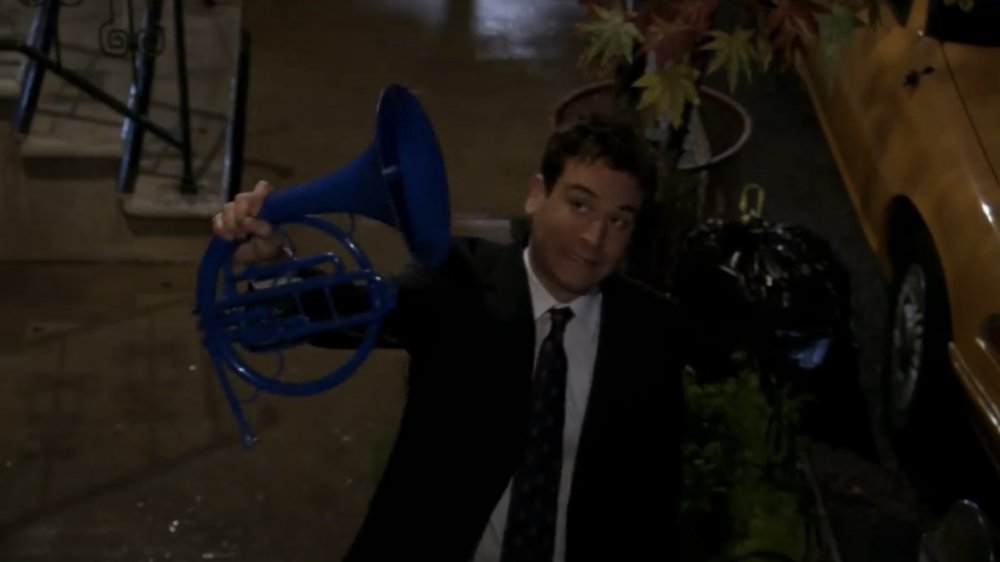 Josh Radnor as Ted Mosby, holding the blue French horn in How I Met Your Mother