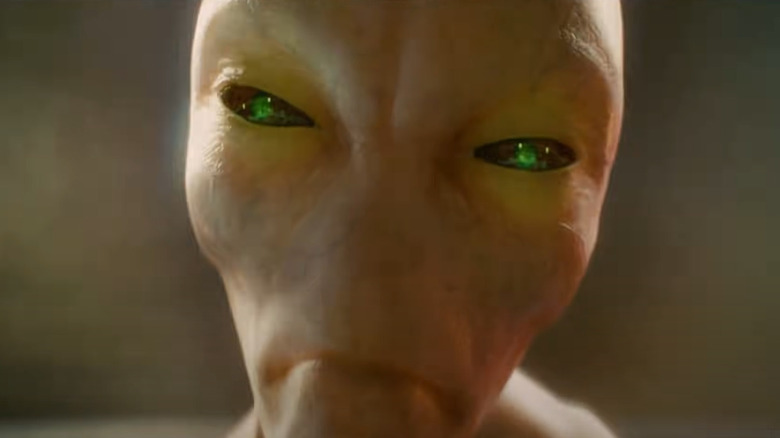 Green-eyed alien peering forward