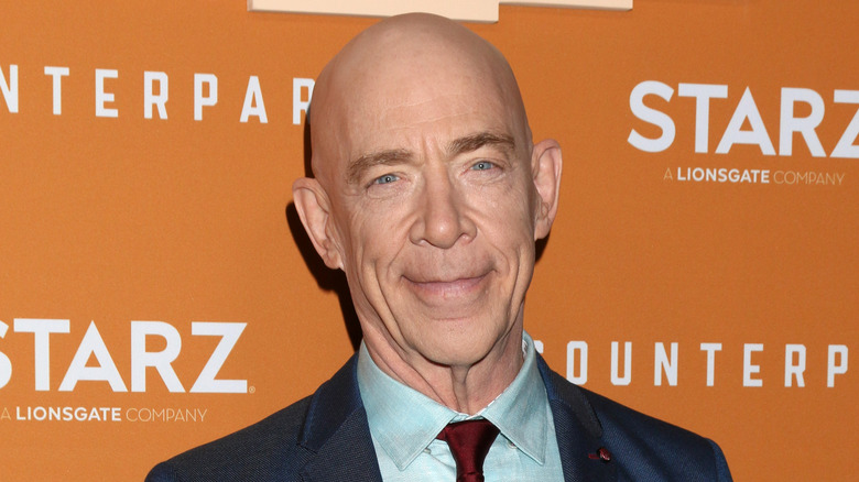 J.K. Simmons smiling in suit