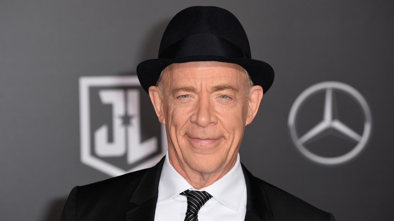 J.K. Simmons smiling wearing fedora