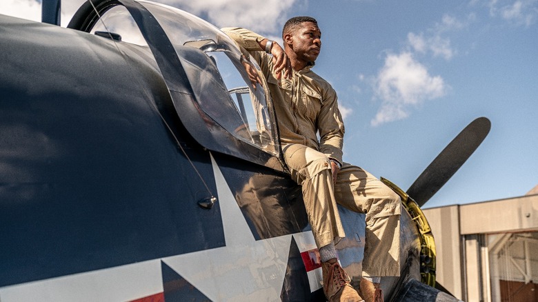 Jonathan Majors as Jesse Brown seated on plane in Devotion