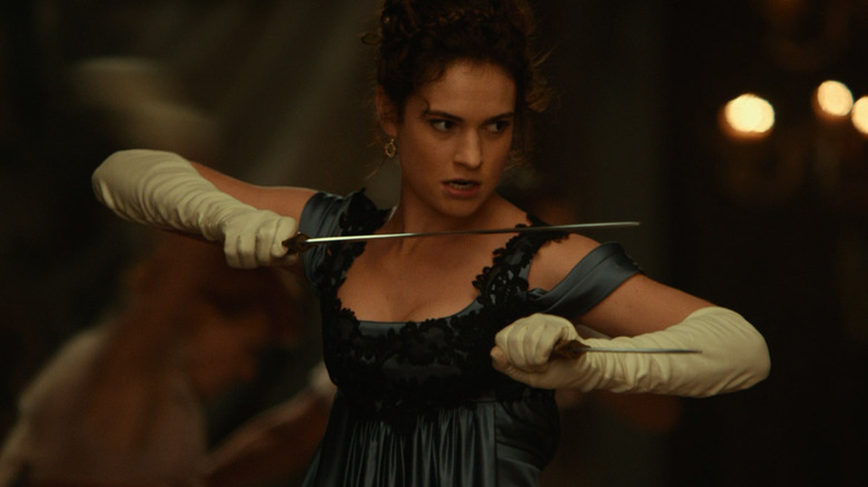 Lily James holding swords