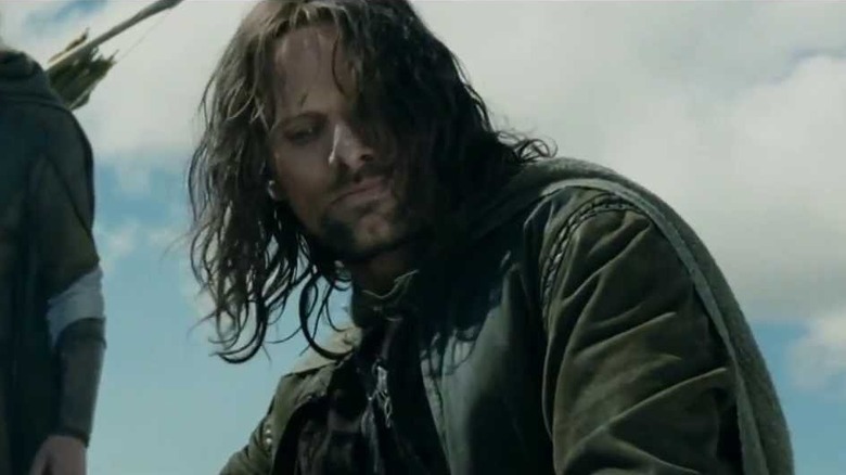 Aragorn kneels after kicking the helmet