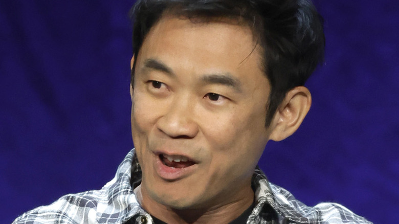 James Wan speaks in front of a blue background