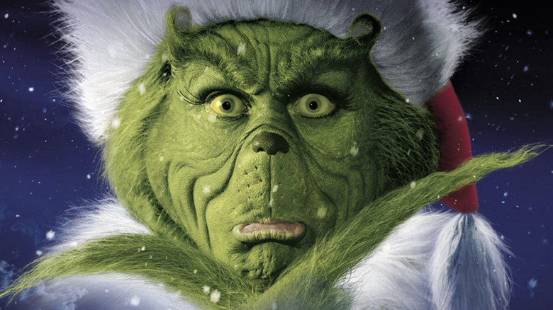 Jim Carrey as the Grinch looking forward through snow on the poster for Dr. Seuss' How the Grinch Stole Christmas (2000)