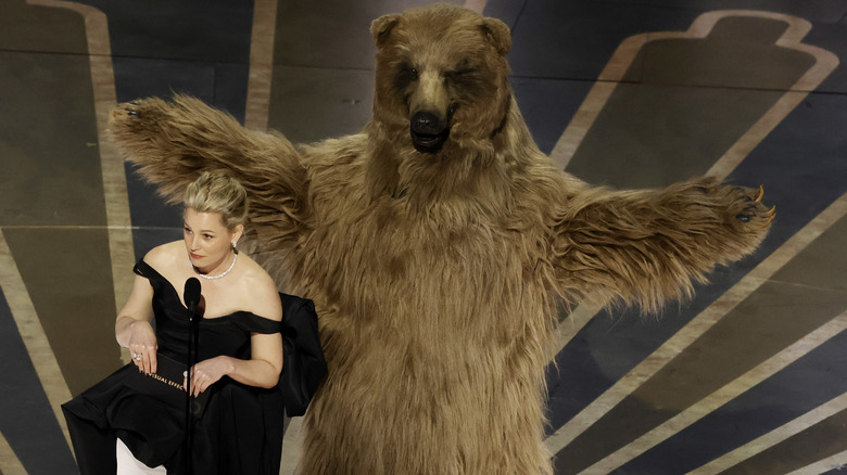 Elizabeth Banks on stage with a large, fake bear