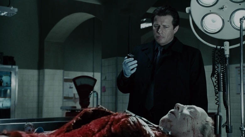 Hoffman holds a tape recorder over Kramer's corpse in "Saw IV" (2007)