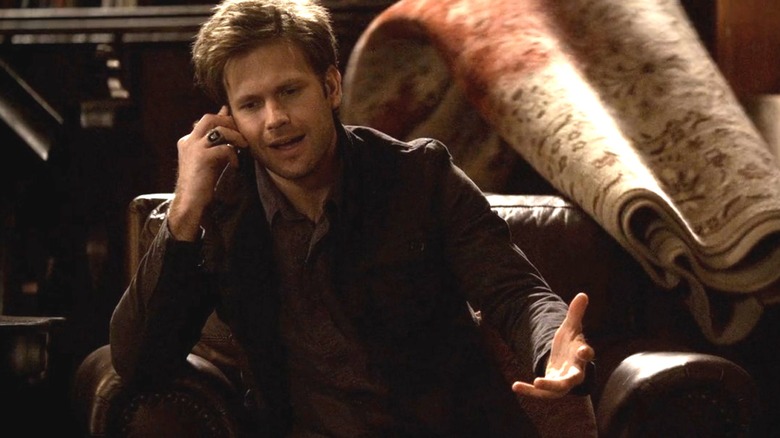 Alaric sits talking on his cell phone in "The Vampire Diaries"