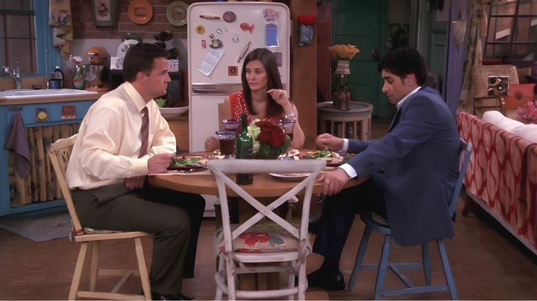 Chandler, Monica and Zack sit at a table.