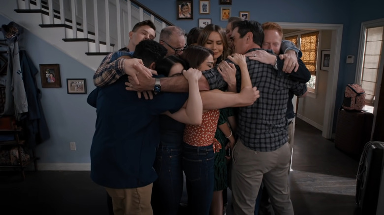 The Dunphy and Pritchett families hugging