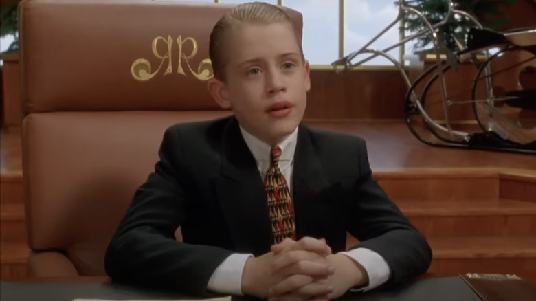 Richie Rich in suit seated