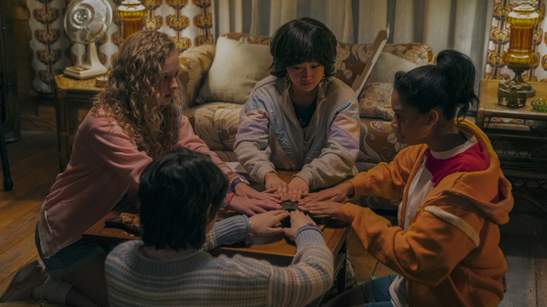 The teen friends of My Best Friend's Exorcism playing with a Ouija board