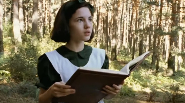 Ofelia staring while holding her book